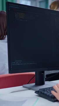 Focused Programming Session: A Developer Engaged in Coding with Modern Monitor Displaying Complex Code in a Bright Office Environment