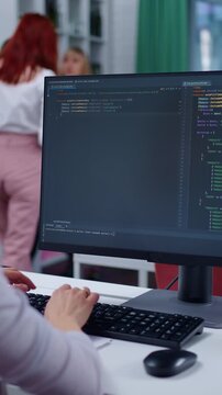 Focused Coding Session: A Programmer Engaged in Software Development While Collaborating in a Modern Office Environment Using a Computer and Programming Tools