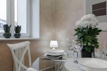 Elegant Dining Table Setting with Flowers, Glassware and Soft Interior Lighting