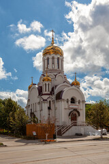 Orthodox church with golden domes under dramatic cloudy sky