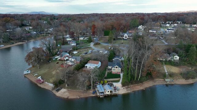 Residential American lakeside neighborhood in Virginia&rsquo;s Timberlake area, with waterfront property, docks, autumn trees and calm blue water in fall. elevated drone shot.