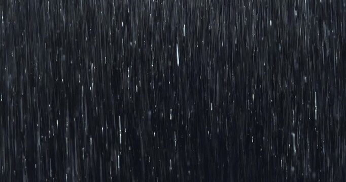Intense wall of rain falling against black. Featuring close-up raindrops splashing on impact. Practical, seamless, loopable VFX element ideal for storm scenes, dramatic moments, atmospheric overlays