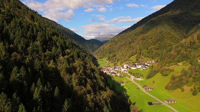 Aerial view of autumn forest and village nestled in Slovenian valley