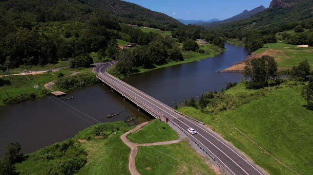 A car drives over a bridge over the Tweed River near Mt Warning, Wollumbin on a sunny day in New South Wales, Australia