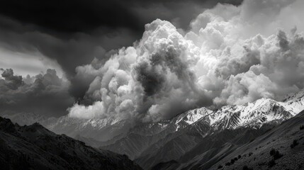 Majestic mountain range under dramatic clouds during an overcast day with snow-capped peaks