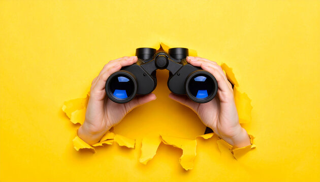 Binoculars vision future business strategy looking search opportunity success focus hands holding binoculars through torn yellow paper conveying