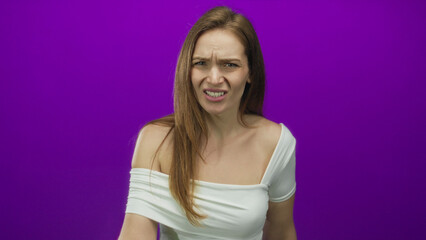 Young woman wearing off shoulder white top shows middle finger with furrowed brows in purple...