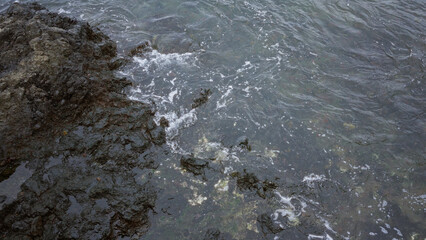 Rocky shore of lanzarote in daylight showcasing rugged coastline and tranquil waves in the canary islands outdoors