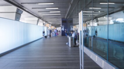Airport terminal defocused interior with blurred walkway, glass reflections and tiled floor;...