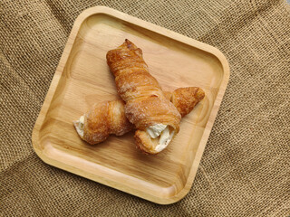 Top view of cream horn bread pastries on wooden board