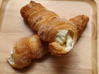 Close up view of cream horn bread pastries on wooden board