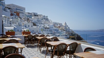 Fototapeta premium Rooftop cafe terrace with shallow blurred bokeh view of white coastal buildings and sea, soft defocused background; background backdrop copyspace calm.