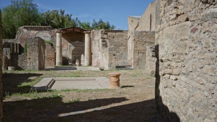 Ancient stone ruins with defocused courtyard, sunlit columns and textured wall foreground outdoor;...