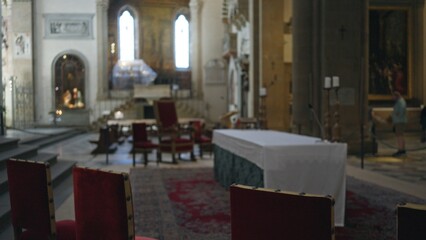 Blurred church interior with soft shallow bokeh highlighting altar and red chairs in a historic cathedral; background backdrop copyspace calm.