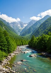 Turquoise river flows through a lush green mountain valley under blue skies.