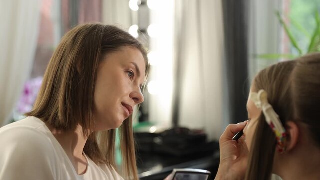 Professional makeup artist applying eyeshadow in a beauty salon