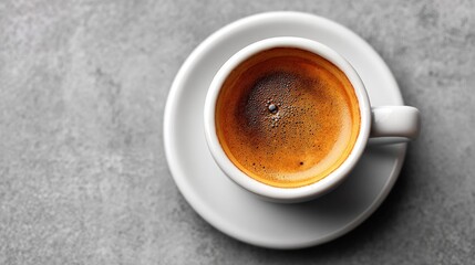 Overhead view of a fresh cup of espresso on a white saucer