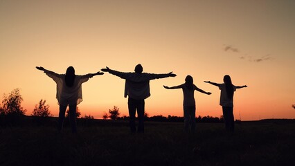 Mother father child kid running towards sunset, happy family, woman, man walking with children park, group people with hands raised sky, faith and hope, nature background sunset, bonding summer