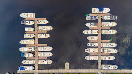 Aerial drone view of marina for river boats, wooden jetty and vacation boats moored top view from above