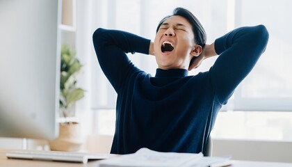 Tired Asian male manager yawning with his hands behind his head in office. Concept for relaxation break, overworked employee and burnout syndrome