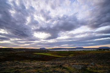 Sunrise scenery over lake Myvatn with mountains and clouds in the sky - Iceland