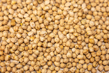 Macro close-up of dry chickpeas. Natural raw legumes used in healthy cooking, vegan recipes, hummus, soups and plant-based protein meals.