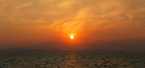 Sunset Over the Sea Under a Wide Orange Clouded Sky