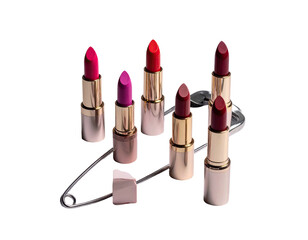 Fototapeta premium Lipsticks arranged on large safety pin, black backdrop