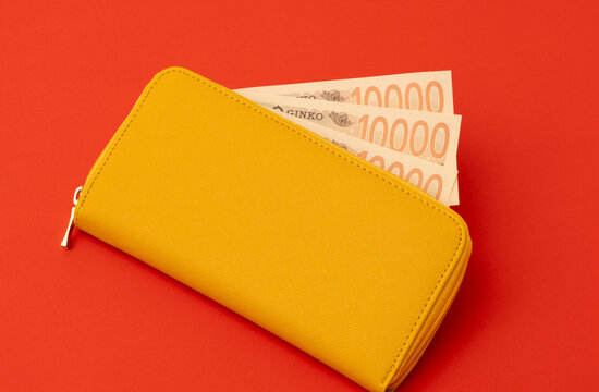 Yellow wallet and Japanese banknotes. Household finances, savings, good fortune, financial luck, deposits, property, expenses, budgets, etc. 黄色の財布と日本紙幣（お金）。家計、預金、幸運、金運、貯金、財産、出費、予算など