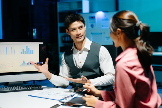 Professional coworkers discussing data and analyzing business reports in a modern office of teamwork, strategy, and corporate collaboration.
