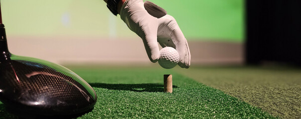 Golfer preparing to tee off at indoor driving range