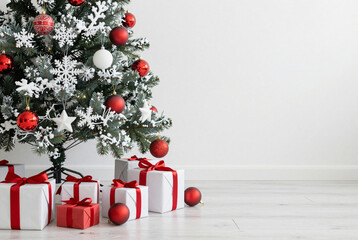 Christmas tree decorated with red and white ornaments and presents.