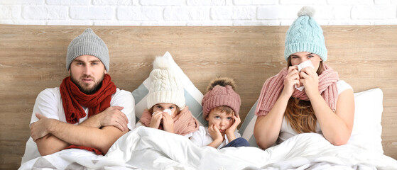 Family ill with flu in bed at home