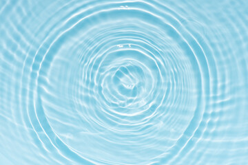 Blue water with ripples on the surface. Defocus blurred transparent blue colored clear calm water surface texture with splashes and bubbles. Water waves with shining pattern texture background.