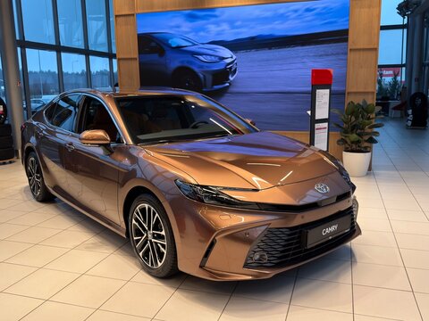 RIGA, LATVIA &ndash; DECEMBER 1, 2025: New Toyota Camry sedan displayed inside a modern car dealership showroom in Riga, Latvia. The image shows the exterior design and front three-quarter view 