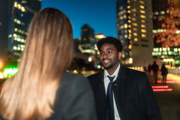 Professional man talking with business colleague in city at night