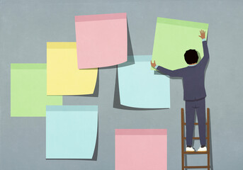 Businessman on ladder hanging large multicolored adhesive notes on gray wall
