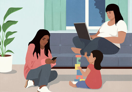 Multiracial females using laptop, smart phone, and playing with toy blocks in living room at night
