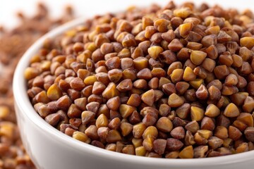 Close Up View of Buckwheat Grains Inside White Bowl on White Surface with Selective Focus