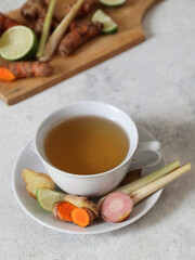 An Indonesian traditional herbal drink called rempah-rempah, or rimpang. Ginger, turmeric, galangal, lime, and lemongrass. Isolated - on grey background