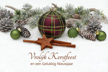 Kerstkaart: Kerstgroet in het Nederlands met kerstballen en dennentakken in de sneeuw. Prettige...