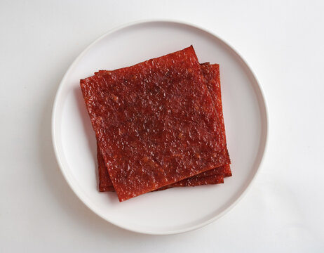 The BBQ Spicy Dried Meat Is On A Flat Plate, Bak Kwa (Top view) isolated on white background