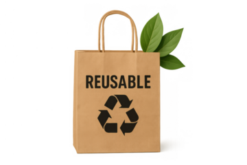 Reusable brown paper shopping bag displaying a recycling symbol and the word reusable, with green leaves appearing from behind, on a transparent background