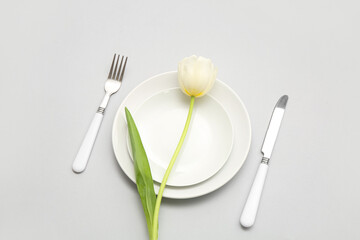 Stylish table setting with beautiful tulip flower on lilac background