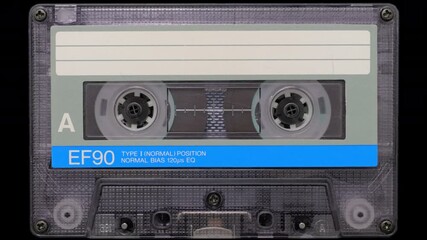 Vintage Audio Cassette Reels Spinning. Retro compact cassette tape with spinning reels on black background.	
 - Powered by Adobe
