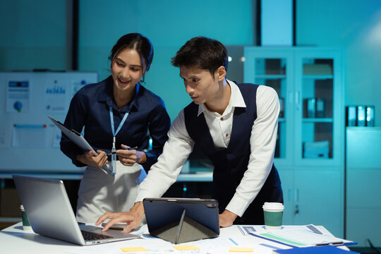 Businessmen team or financial data analysts working overtime with tablets and laptop computers and data graphs together. - Powered by Adobe