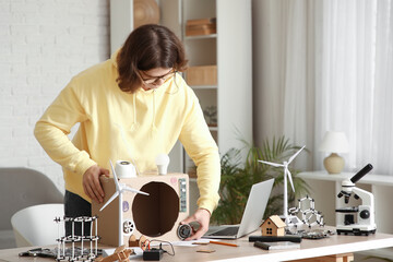 Male inventor with device on table at home