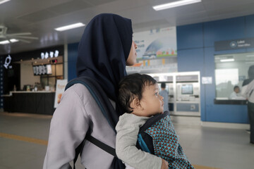 Mother Carrying Toddler in Front Carrier