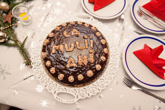 Chocolate birthday cake with la mulțI ani on festive winter table with holiday decor