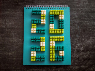 Colorful building blocks forming the numbers 2026 on tosca notebook against a dark table. Perfect for celebrating New Year's Eve or welcoming the new year with festivities